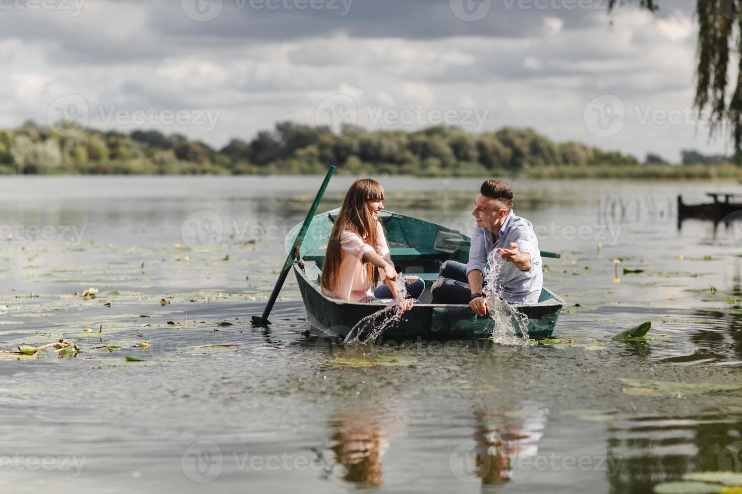 sintiéndose juguetón. hermosa pareja joven disfrutando de una cita romántica mientras rema un bote. felices de tenernos el uno al otro. foto