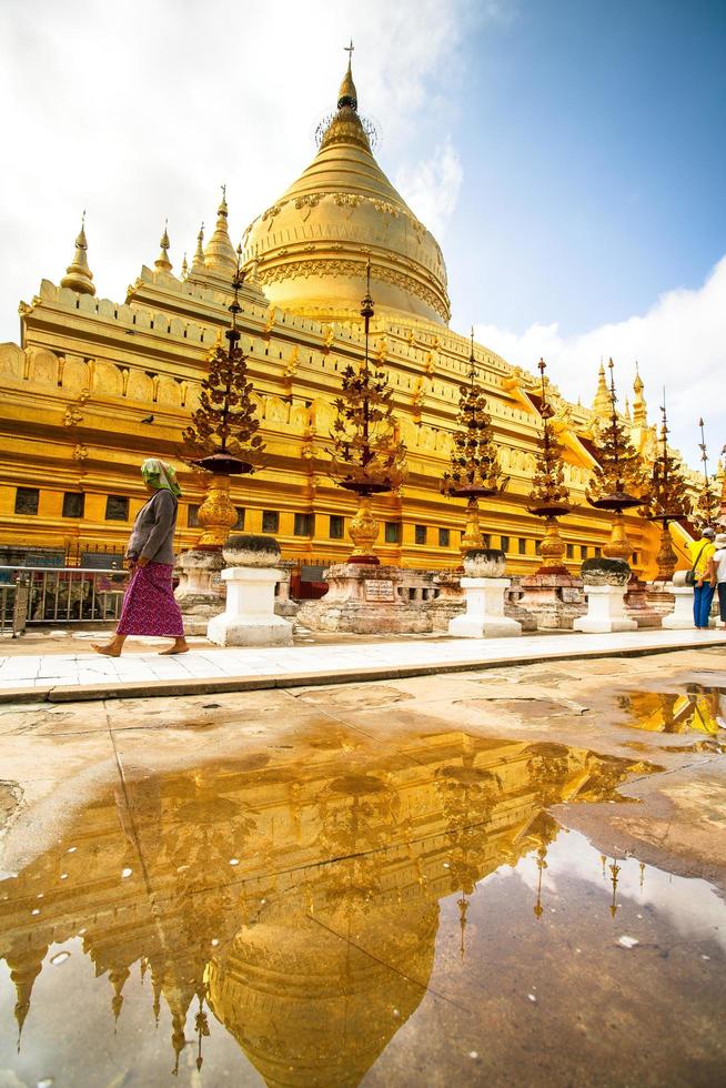 Bagan, Mandalay region, Myanmar - January 9, 2019 - Tourists visit at Shwezigon Pagoda, or Shwezigon Paya, a Buddhist temple located in Nyaung-U, a town near Bagan photo