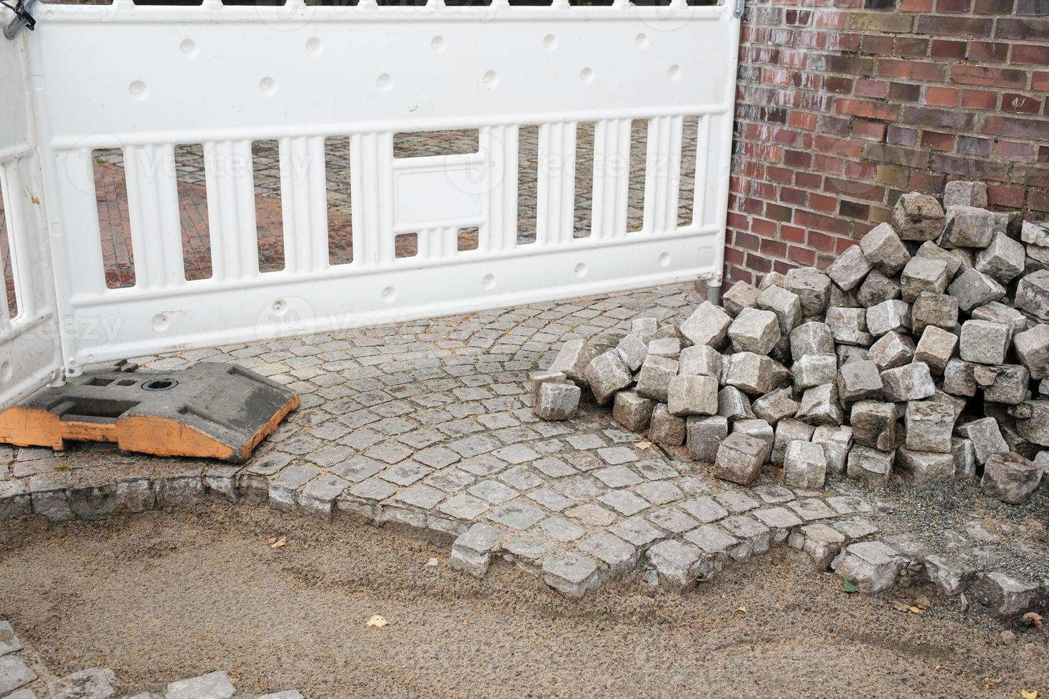 repair of paving stones of a pedestrian path on a city street in Europe