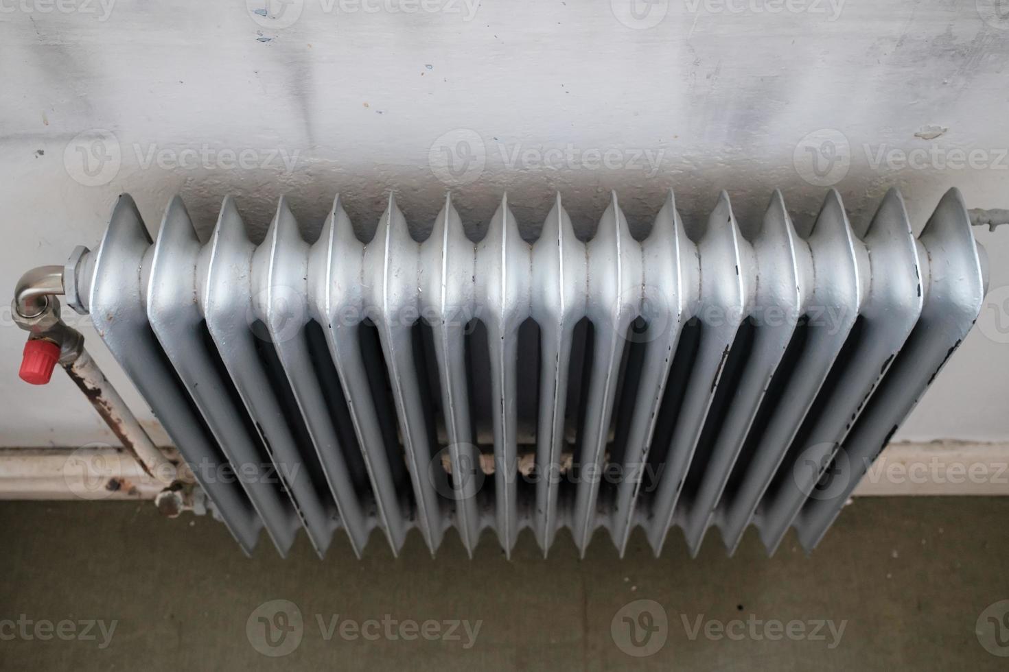 Old radiator with a valve that turns the heating on or off. Energy crisis concept. photo