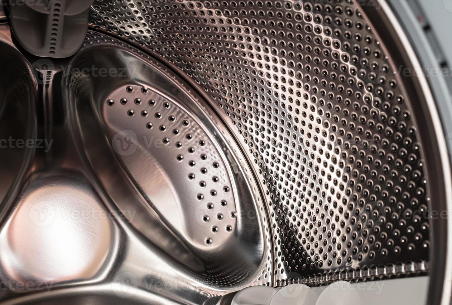 Closeup of a washing machine drum with the door open to dry and ventilate inside the washer