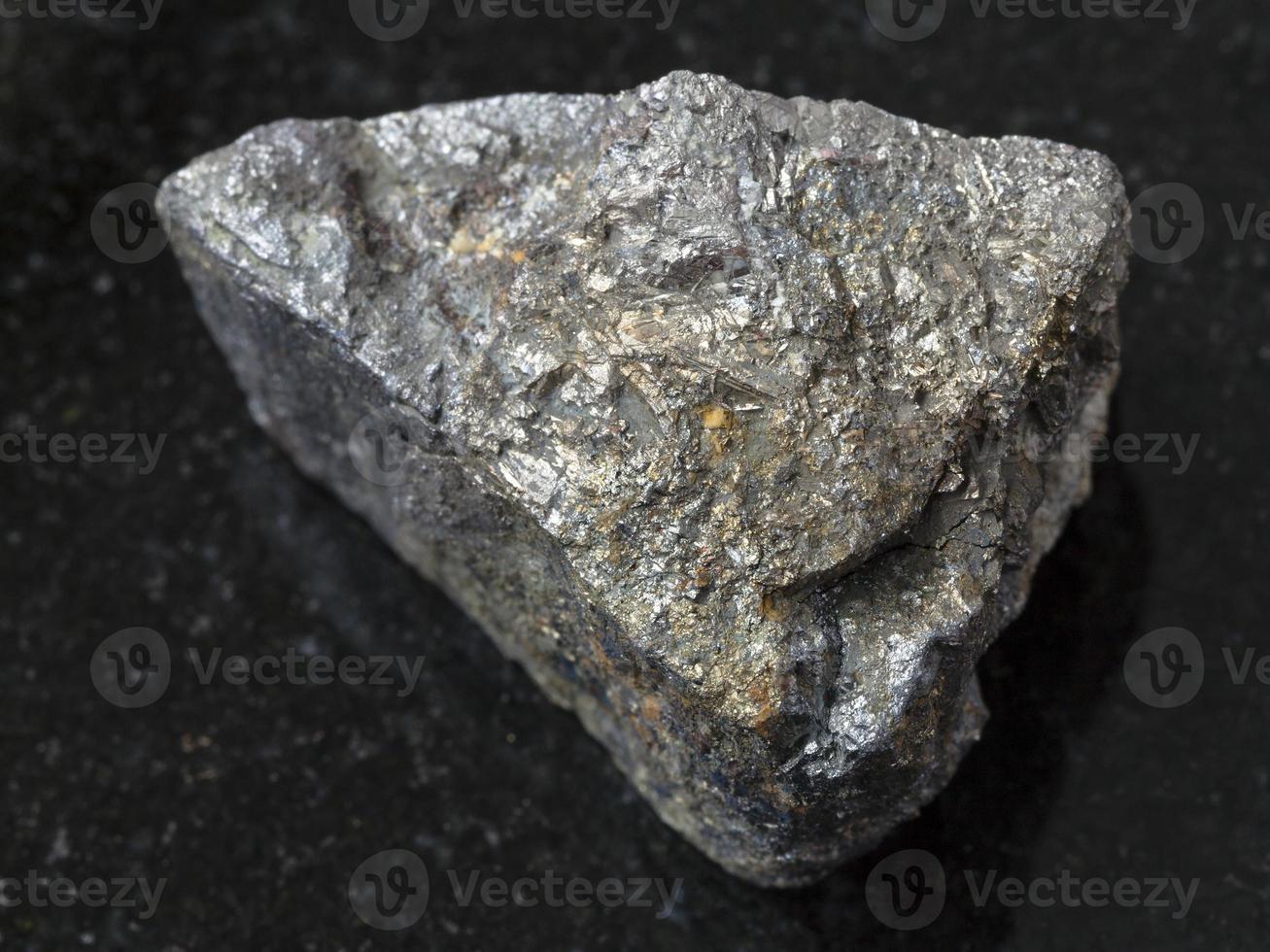 raw Arsenopyrite stone on dark background photo