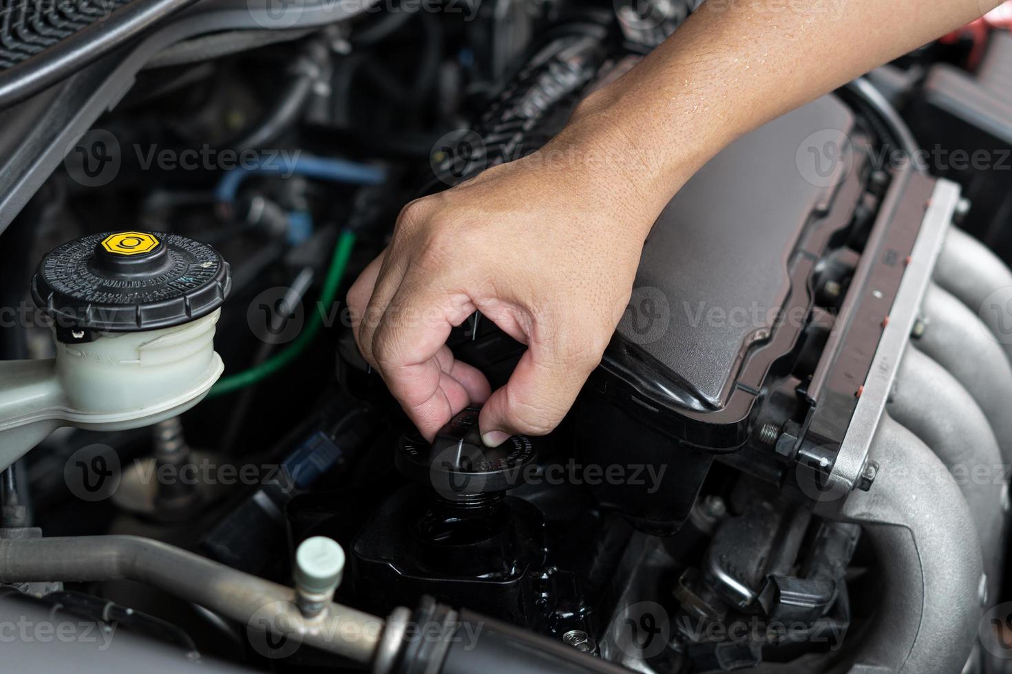 Car technician man use screwdriver remove bolt in engine room service and maintenance concept photo