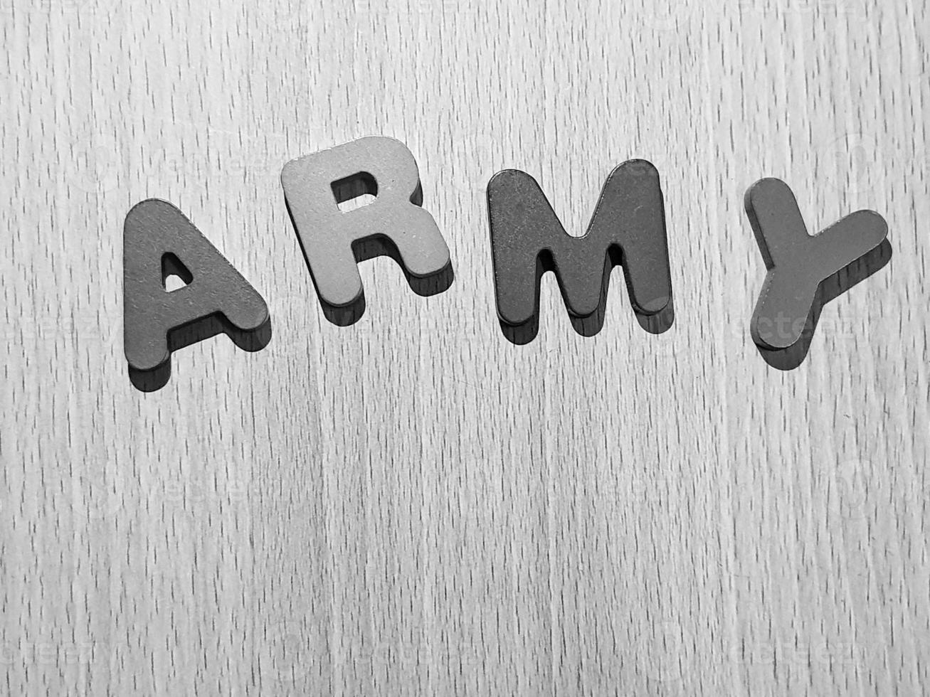 Black and white photo of the alphabet on a wooden table that says ARMY.