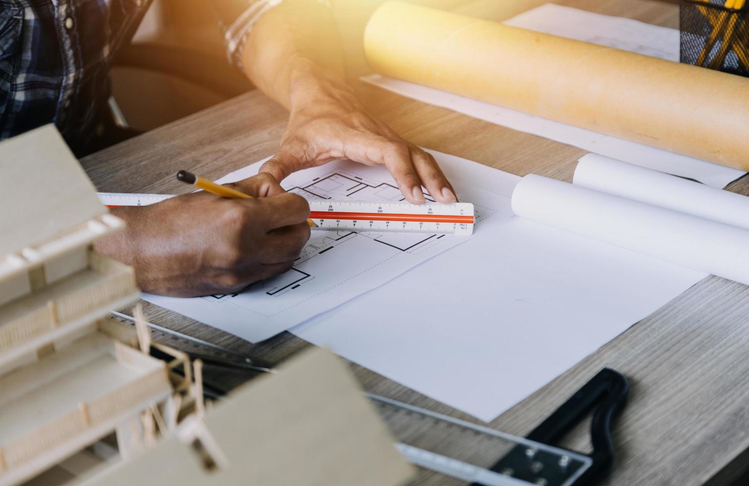 Construction engineer working at blueprint to build large commercial buildings in office. Engineering tools and construction concept. photo
