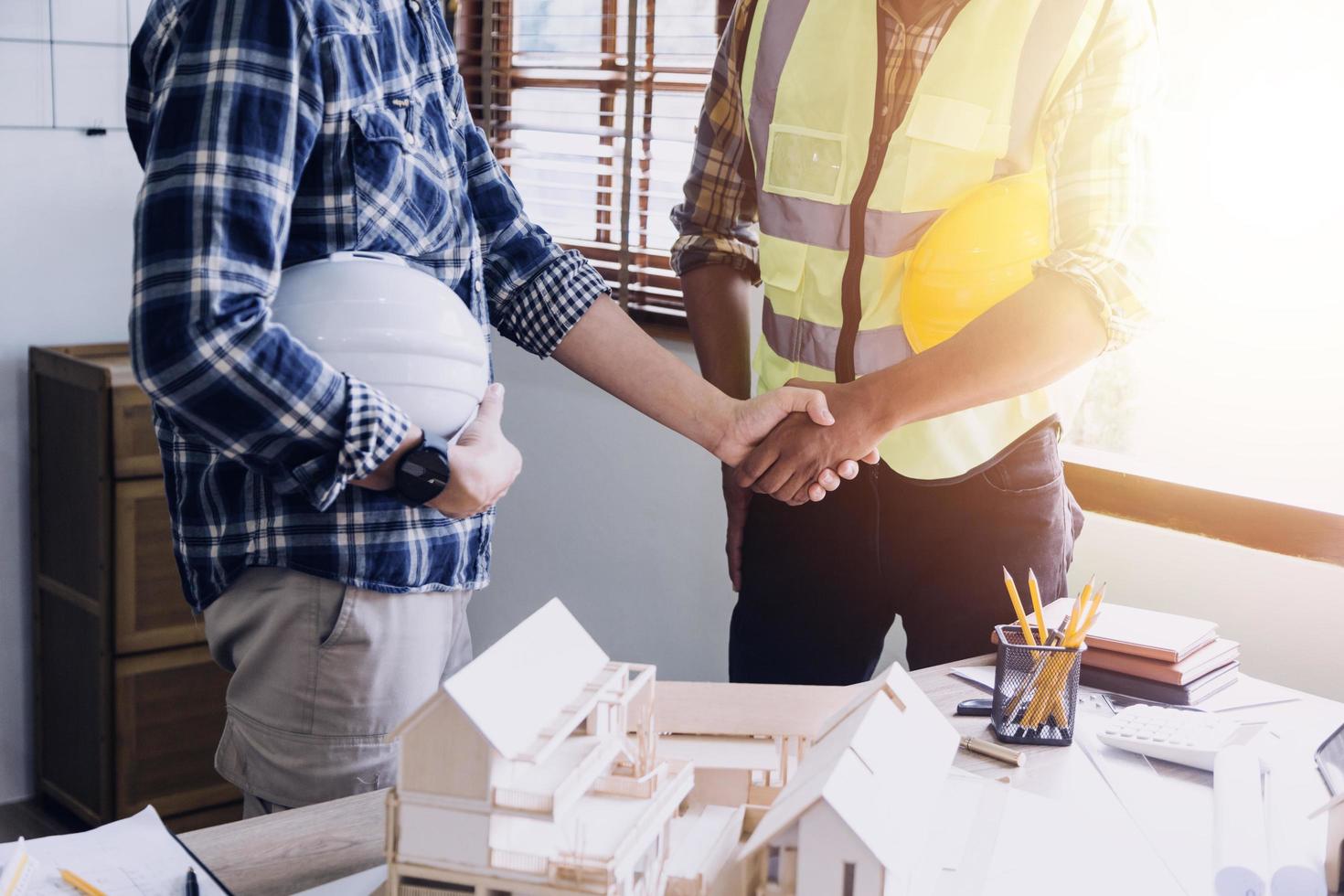 ingeniero de construcción que trabaja en planos para construir grandes edificios comerciales en la oficina. herramientas de ingeniería y concepto de construcción. foto