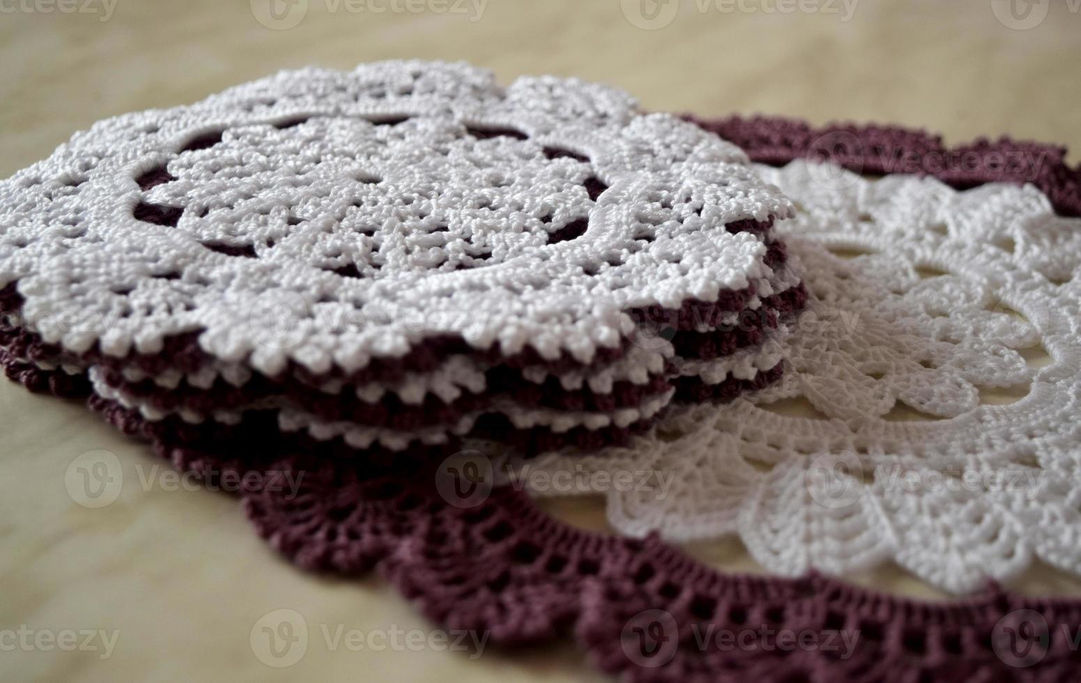 White and purple hand hooked coaster. Knitted holders for hot work photo