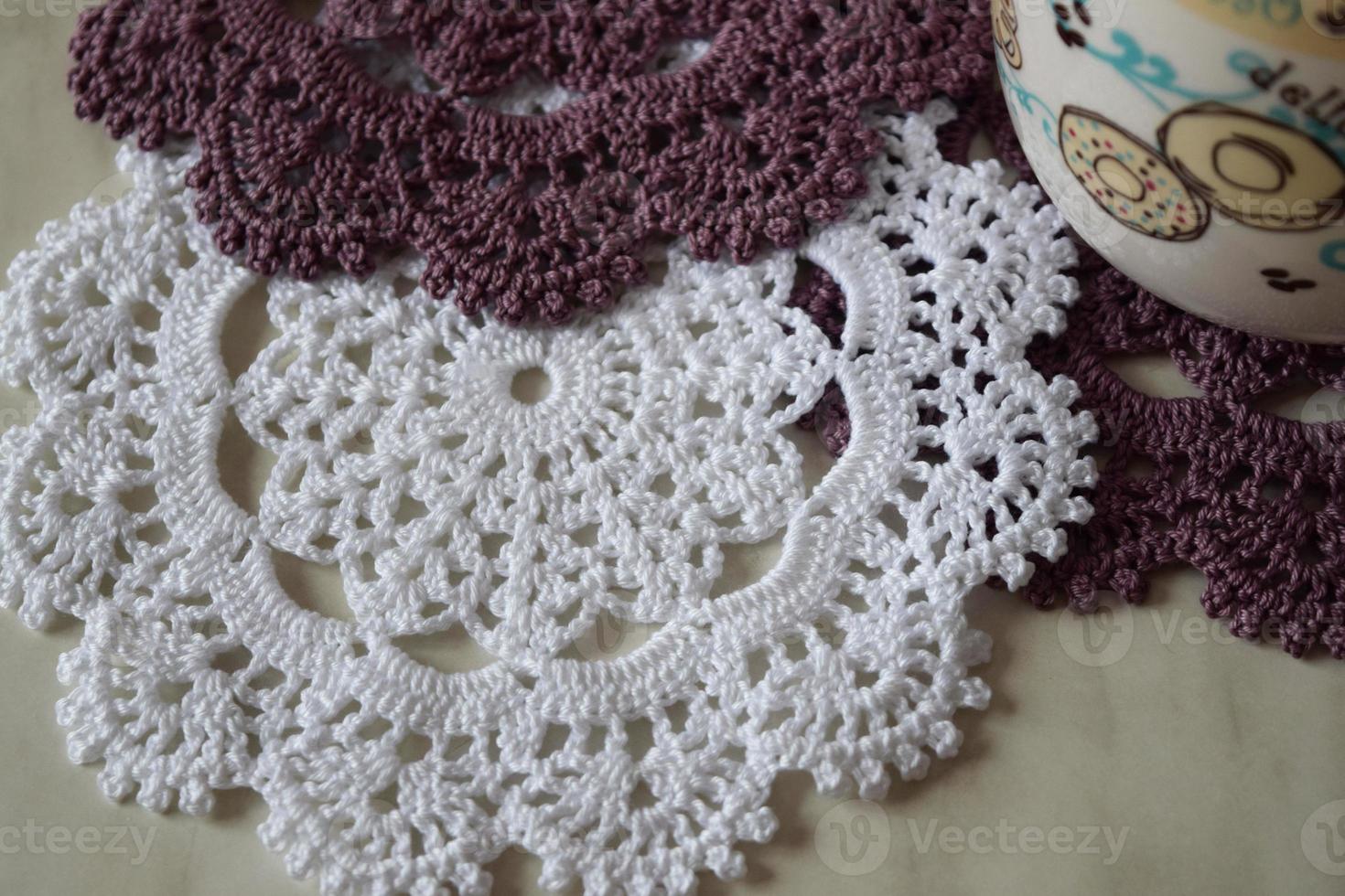 White and purple hand hooked coaster. Knitted holders for hot work photo