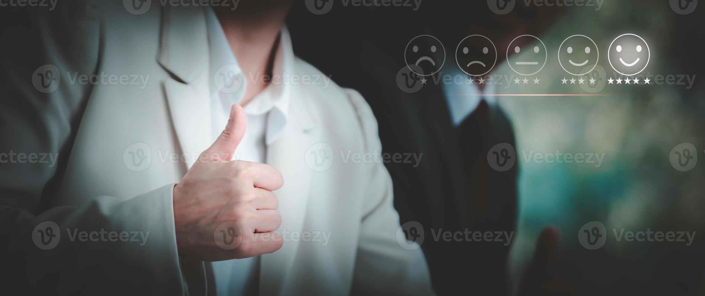Businesswoman showing thumbs up for customer services satisfaction, smiling face emoticon. Customer service evaluation concept. photo