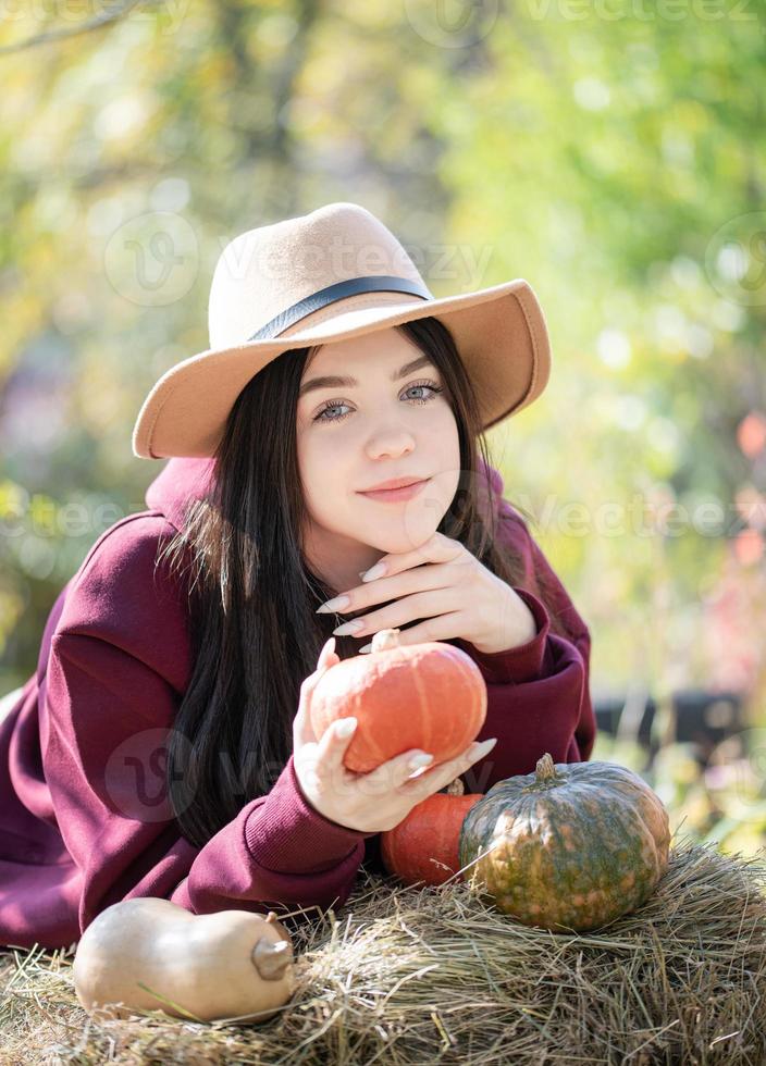 niña feliz con calabaza en el jardín de otoño foto