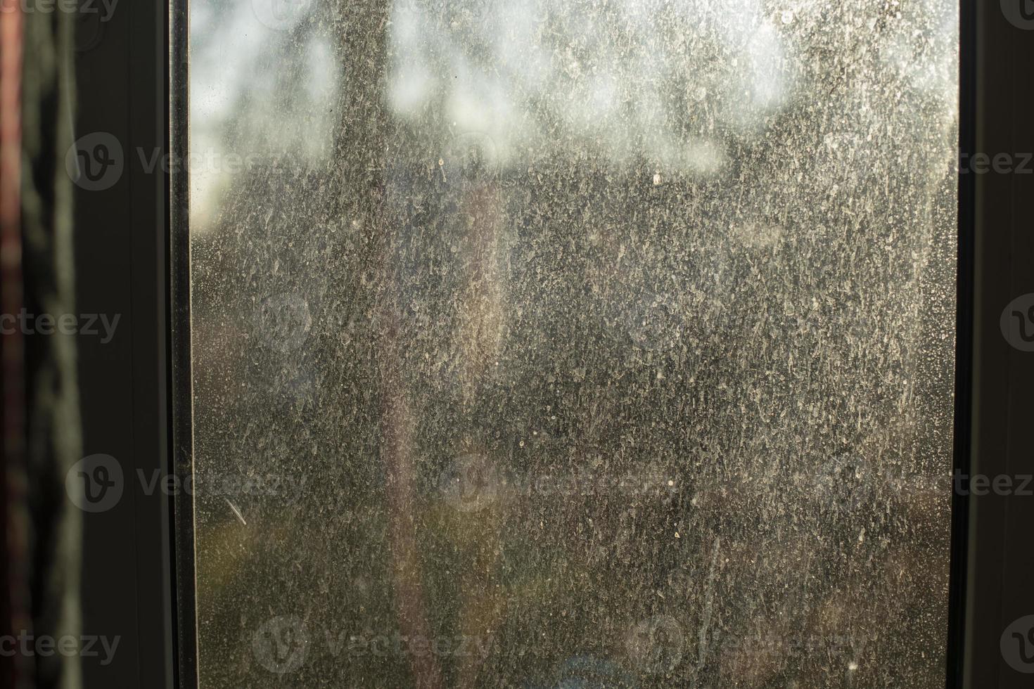 Dust on glass. Dirty window in morning. Surface in fine sand. photo