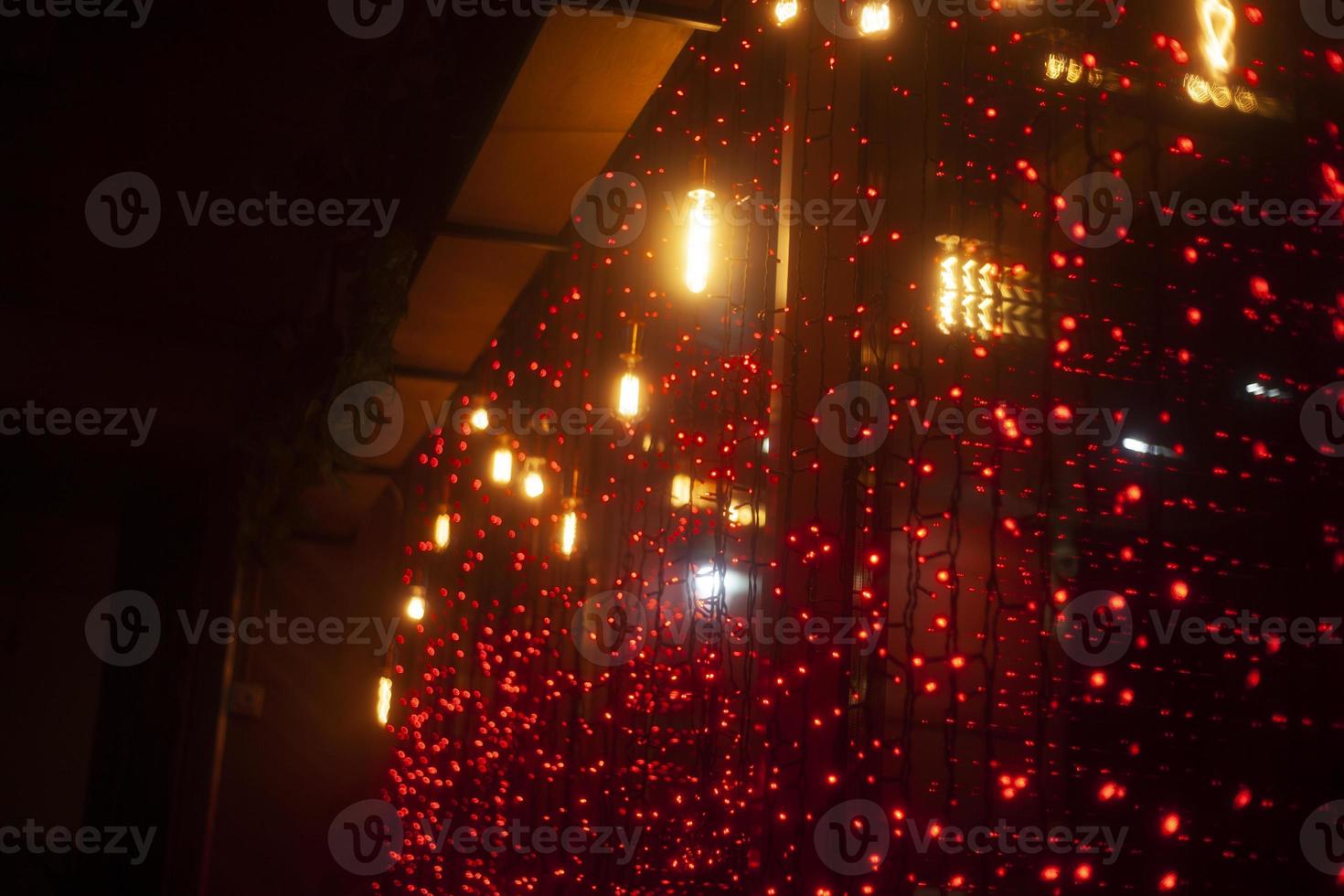 Red garlands on glass. Interior details. Window garland decoration. photo