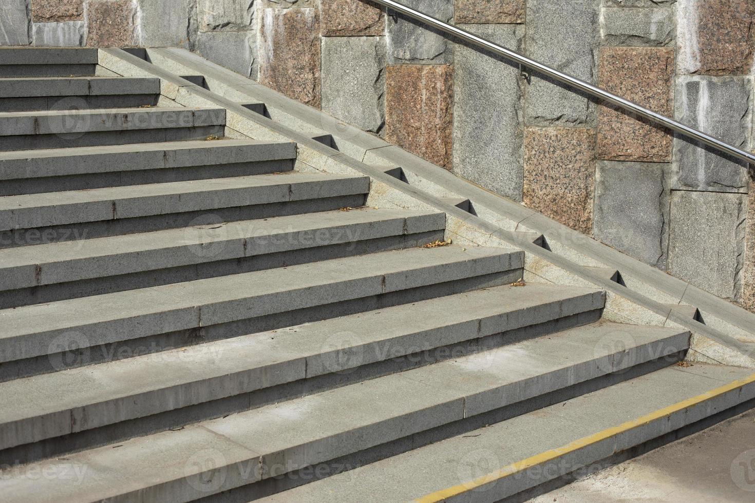 Descent of baby stroller on stairs. Woman lowers stroller with child. Stairs in park. photo
