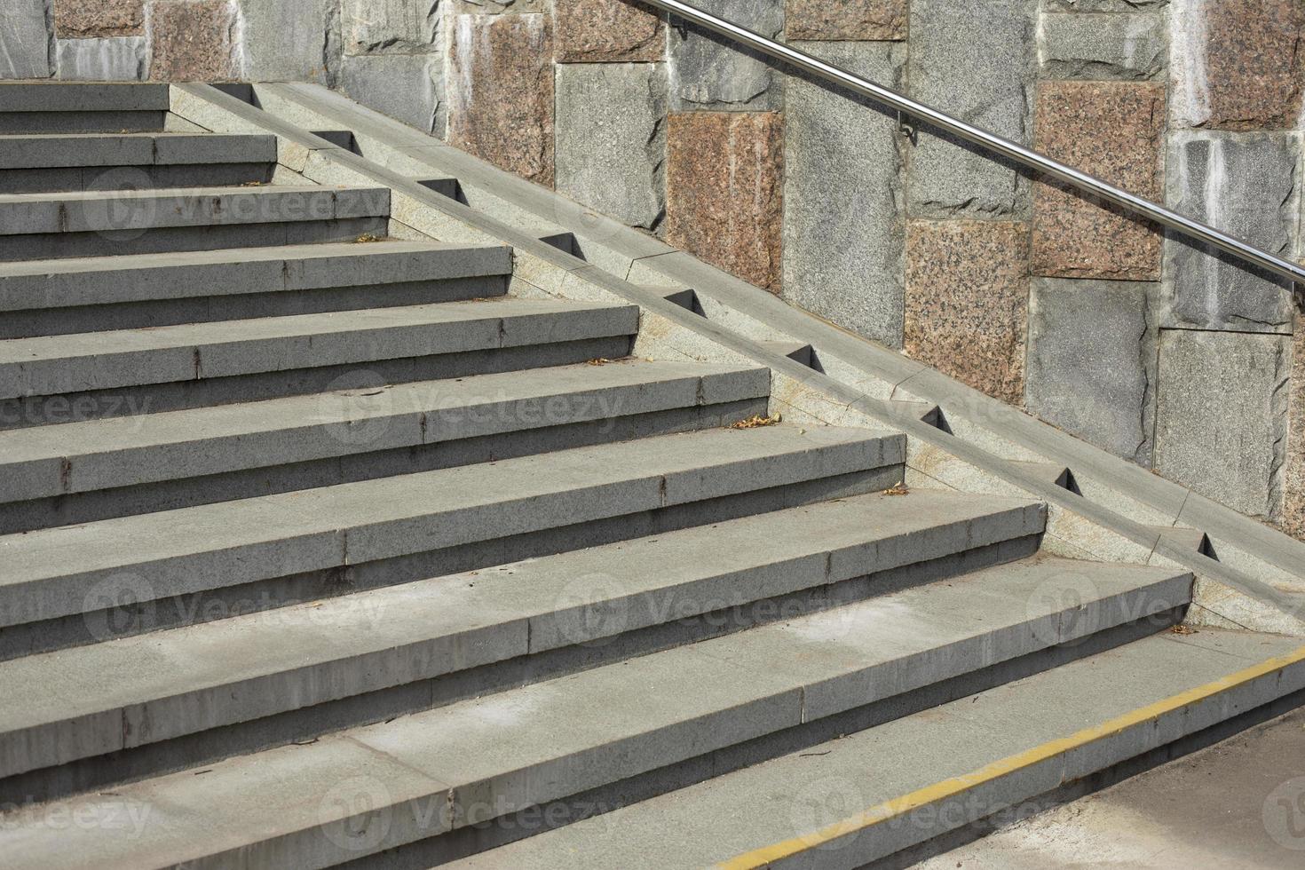 descenso del cochecito de bebé en las escaleras. la mujer baja el cochecito con el niño. escaleras en el parque. foto