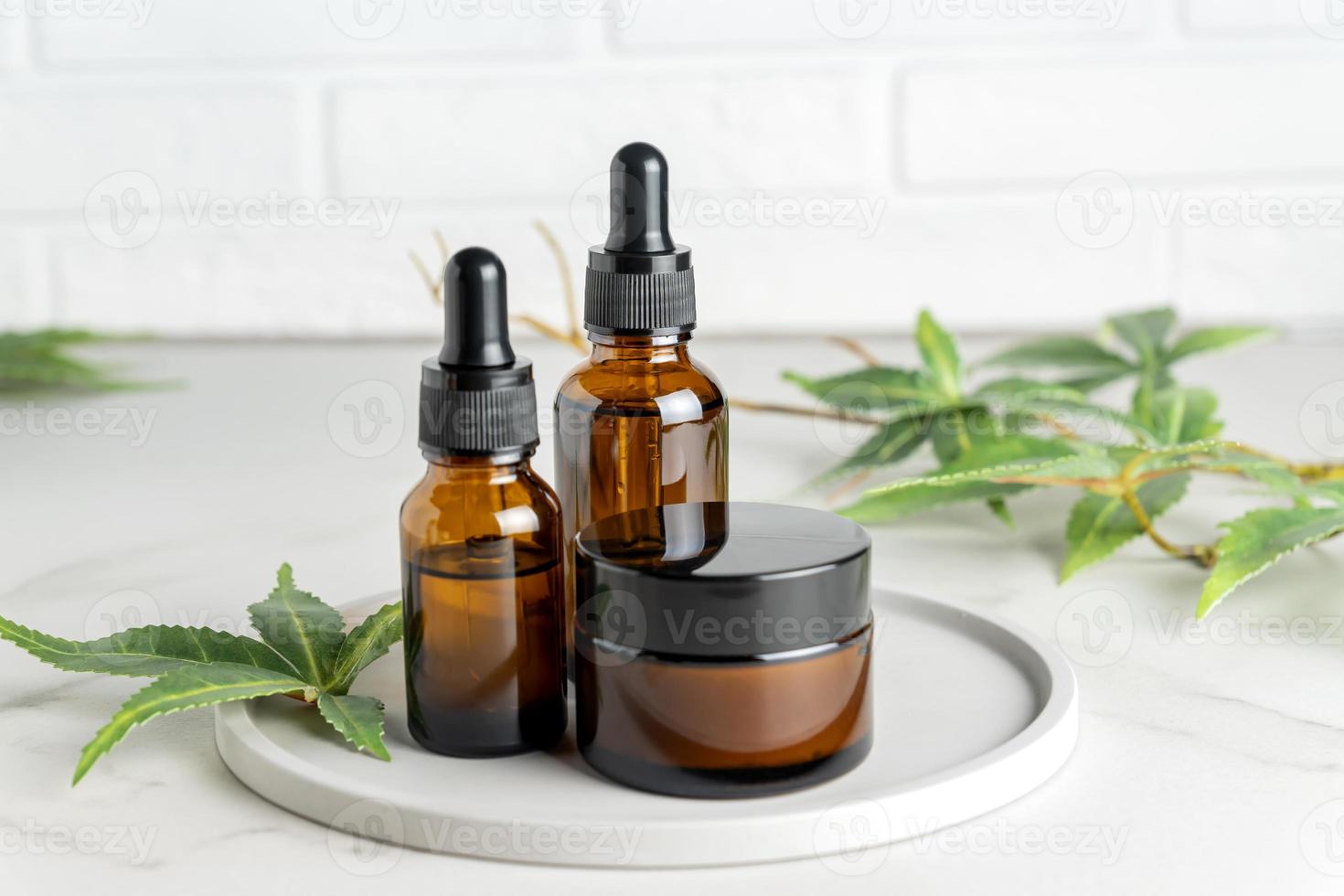 Hemp cbd oil serum in glass dropper bottles with cannabis leaves, Moisturizing cream, Cannabis leaf with skincare cosmetics. Medical marijuana product. photo