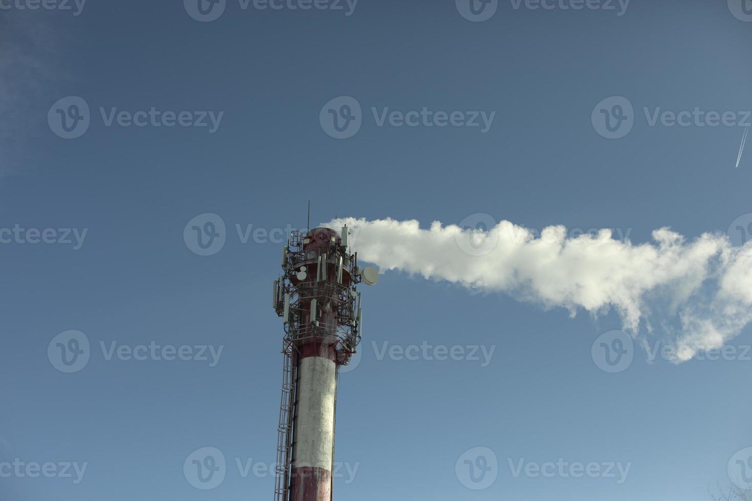 Chimney with smoke. Boiler station. Industrial pipe on sky. photo