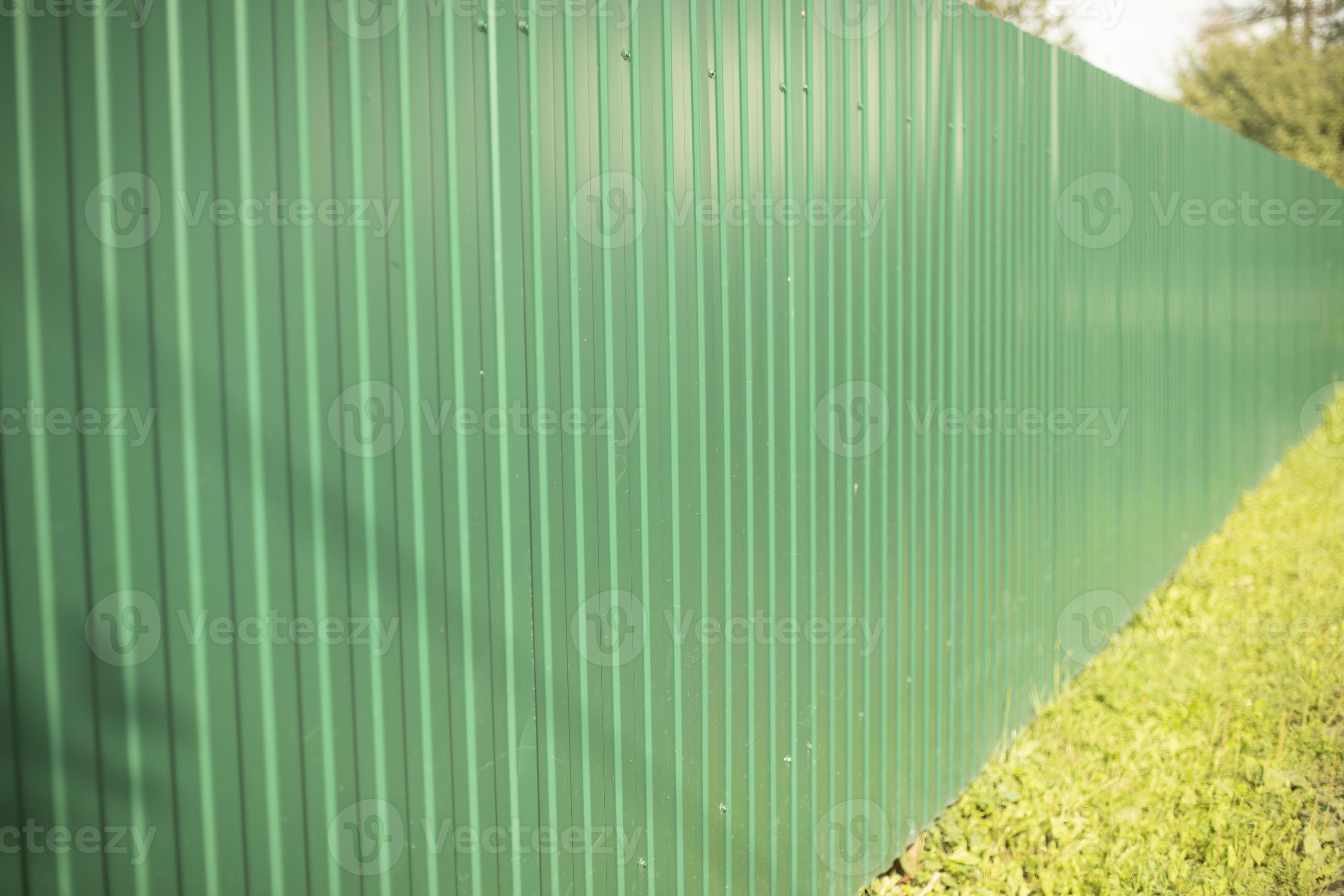 Green fence made of steel profile. High fence. Private territory