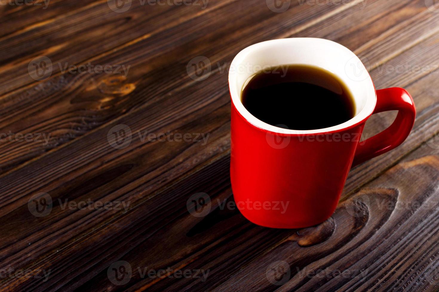 red cup coffee on dark wood background photo