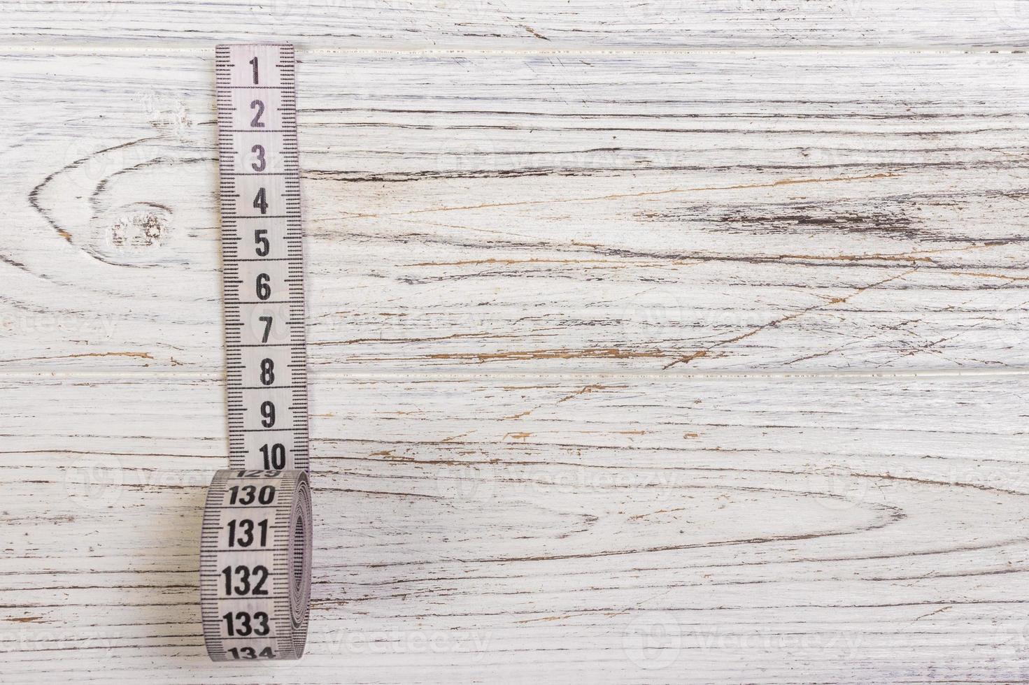 Tailoring Meter White measuring tape on wooden background photo