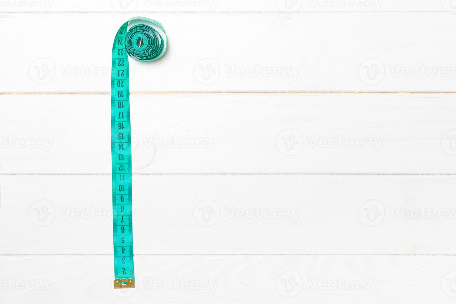 Top view of measure tape in the form of frame on wooden background. Balanced eating concept with copy space photo