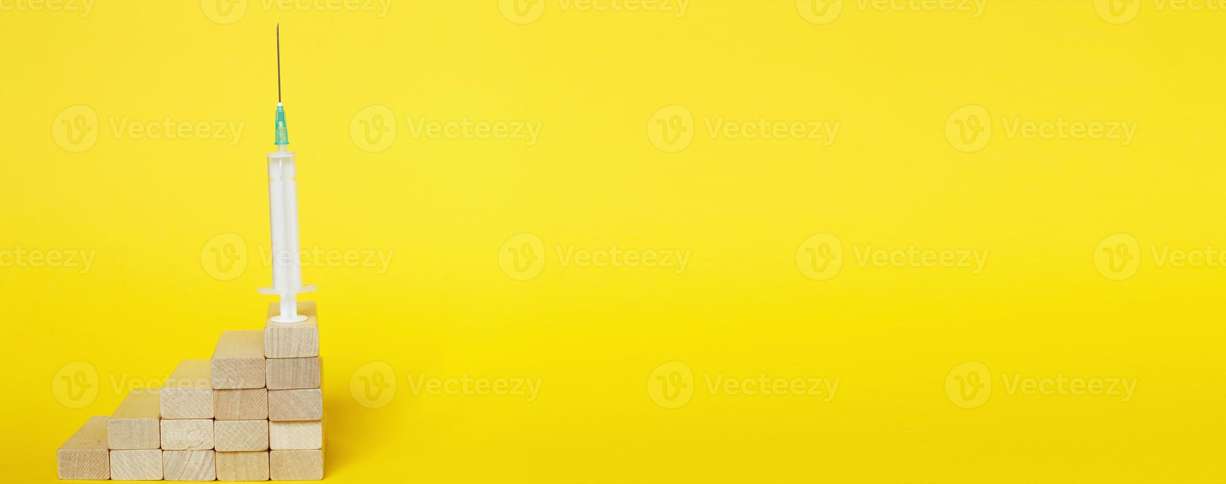 medical syringe on ladder made of wooden sticks. drugs, vaccination concept photo