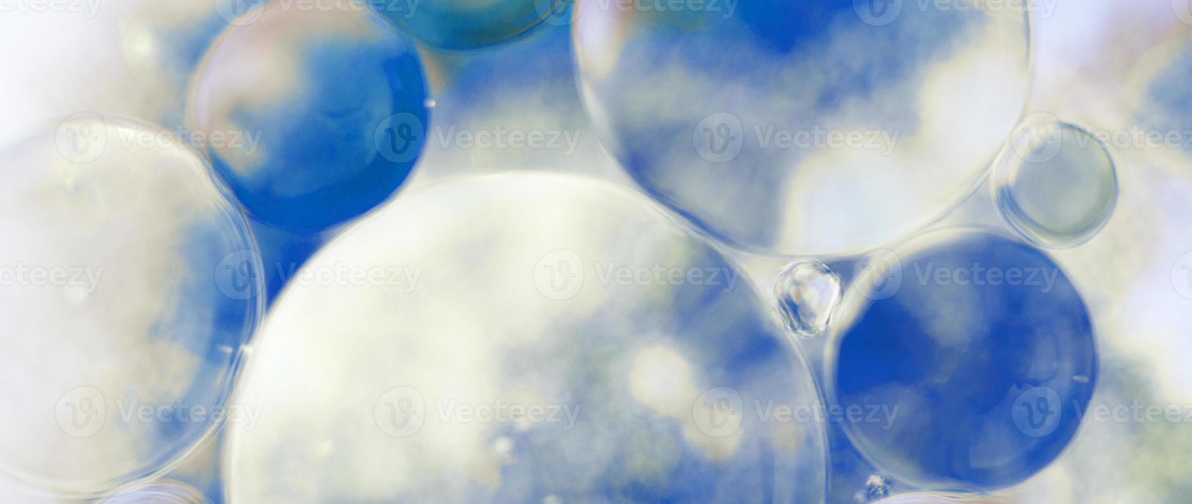 las burbujas de aceite se cierran. círculos de agua macro. fondo azul claro abstracto. bandera foto