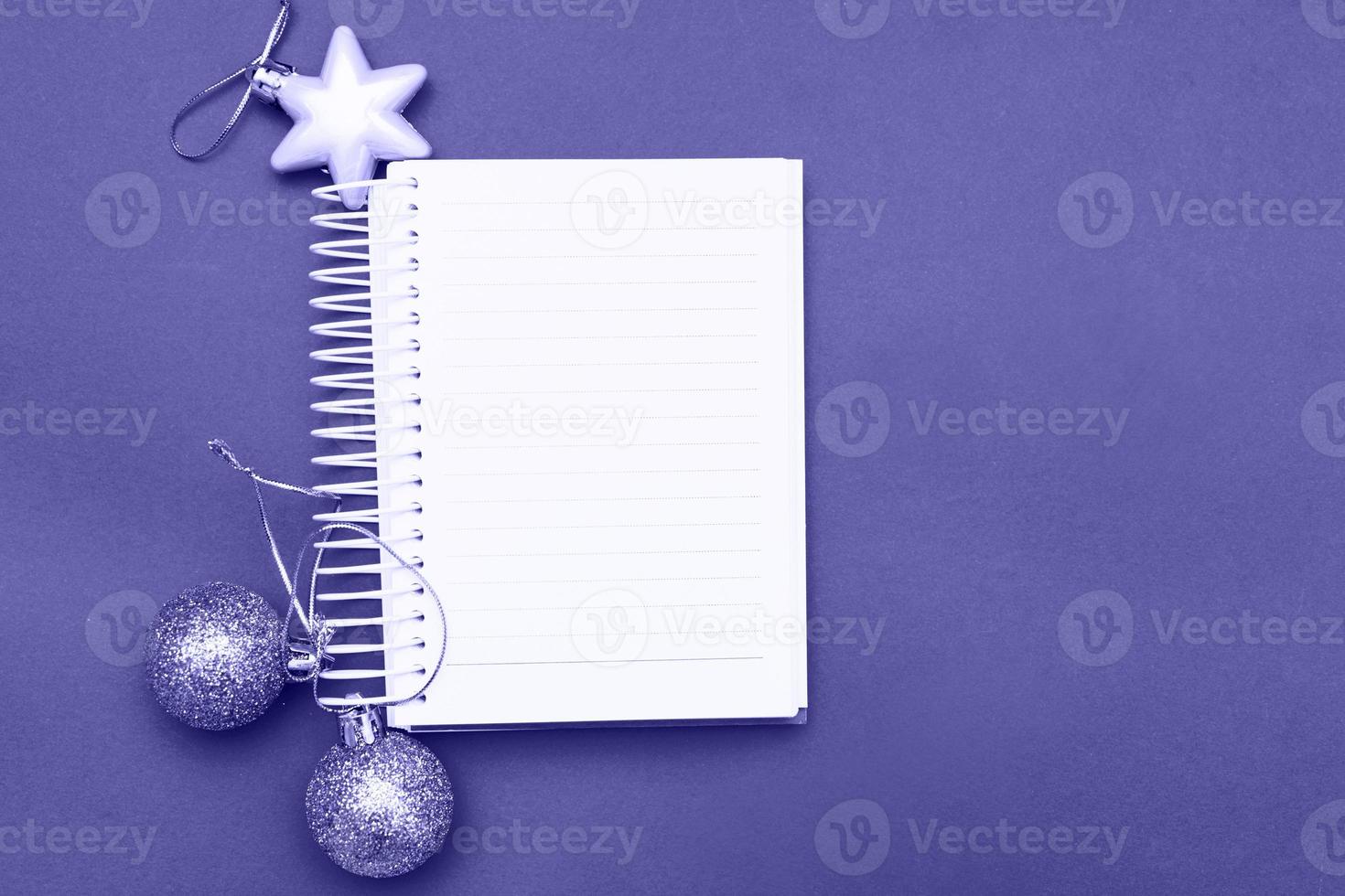 Christmas balls and toys with empty blank note sheet on a blue background photo