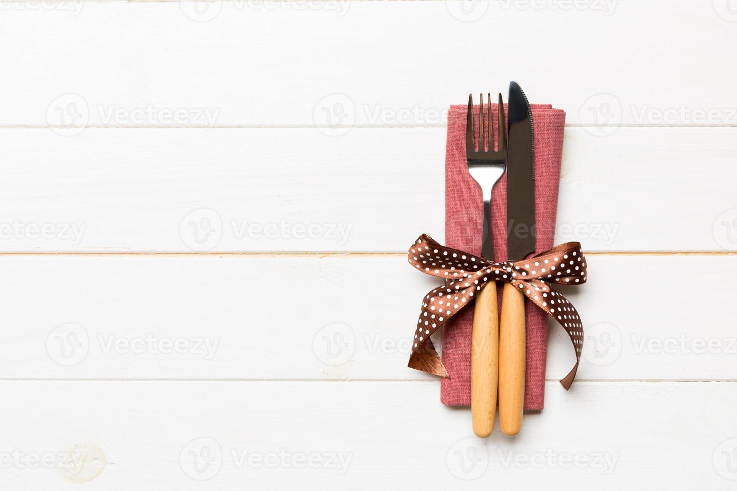 Top view of fork and knife on napkin on wooden background. Different christmas decorations and toys. New Year dinner concept with empty space for your design photo