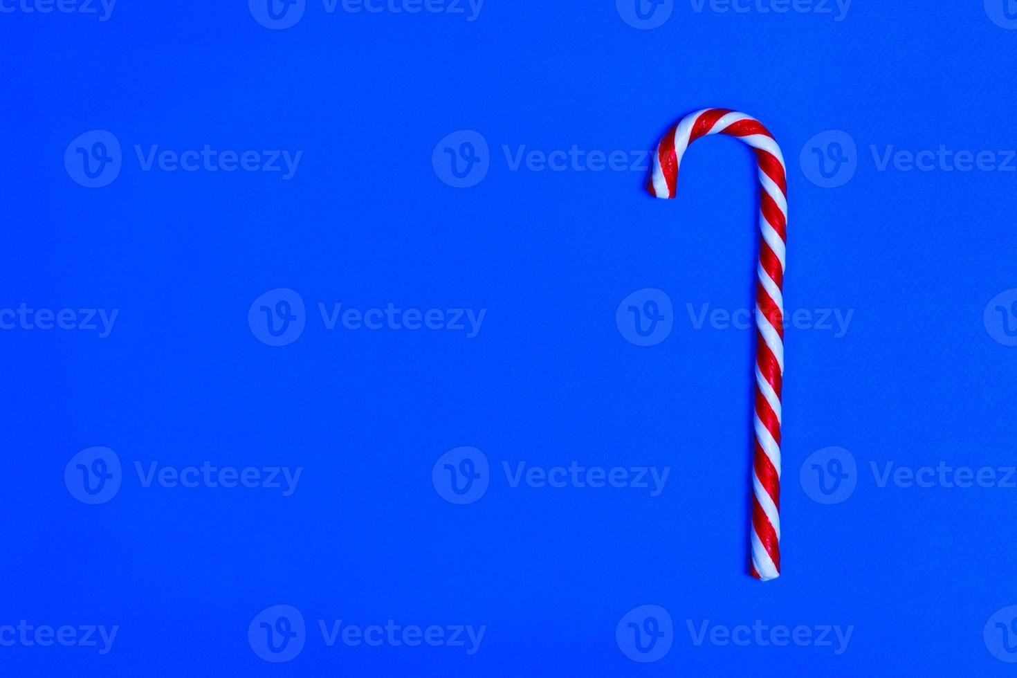 Christmas candy cane on blue background. Flat lay and top view. copy space photo