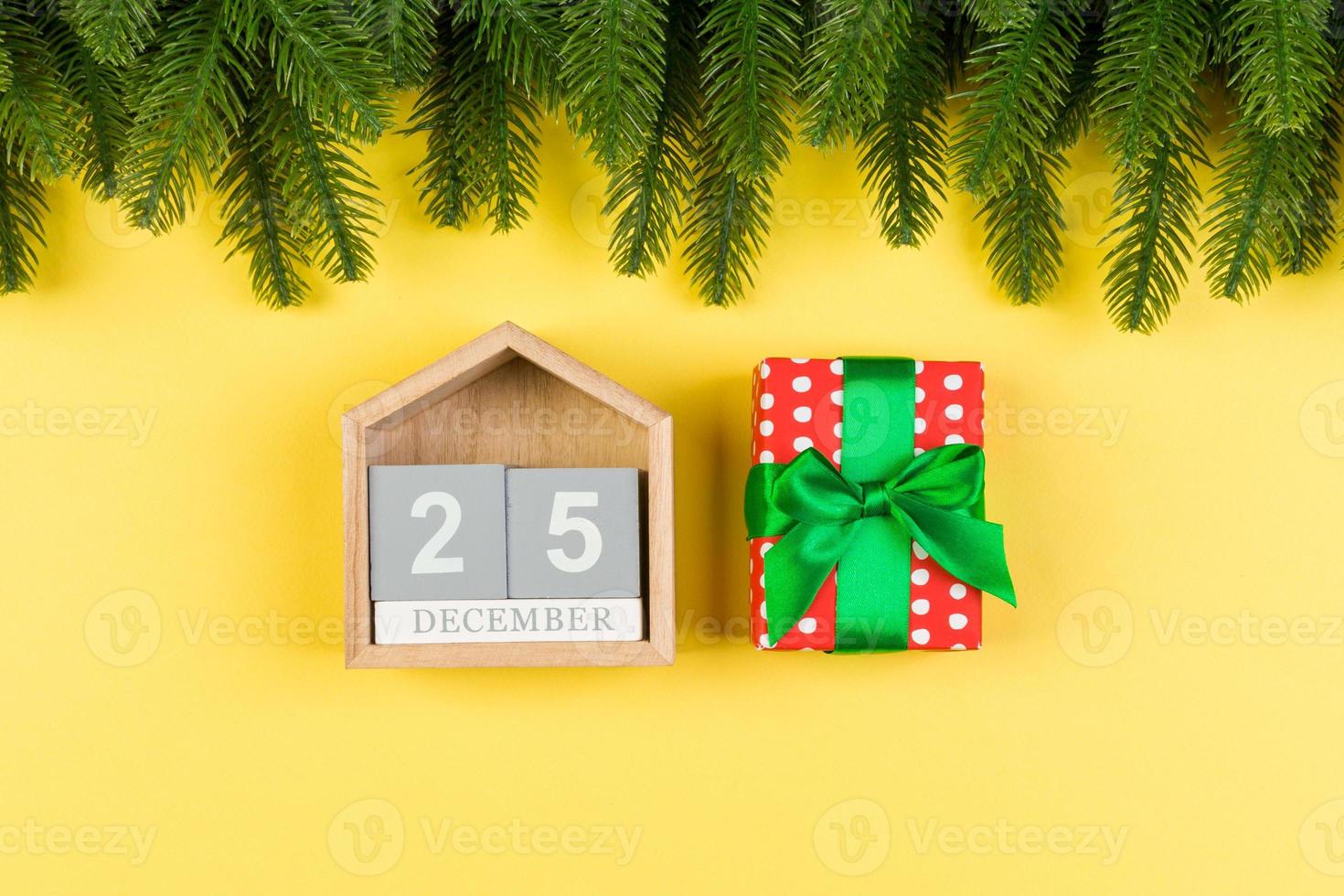 Top view of fir tree, wooden calendar and gift box on colorful background. The twenty fifth of December. Merry Christmas time with empty space for your design photo