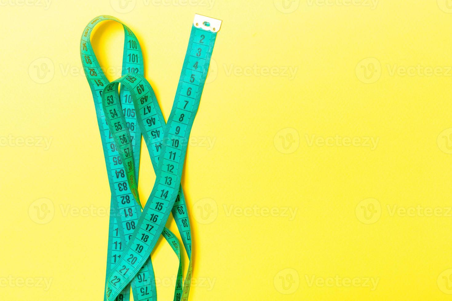Top view of measuring tape on orange background. Tailor and slim waist concept with emty space for your idea photo