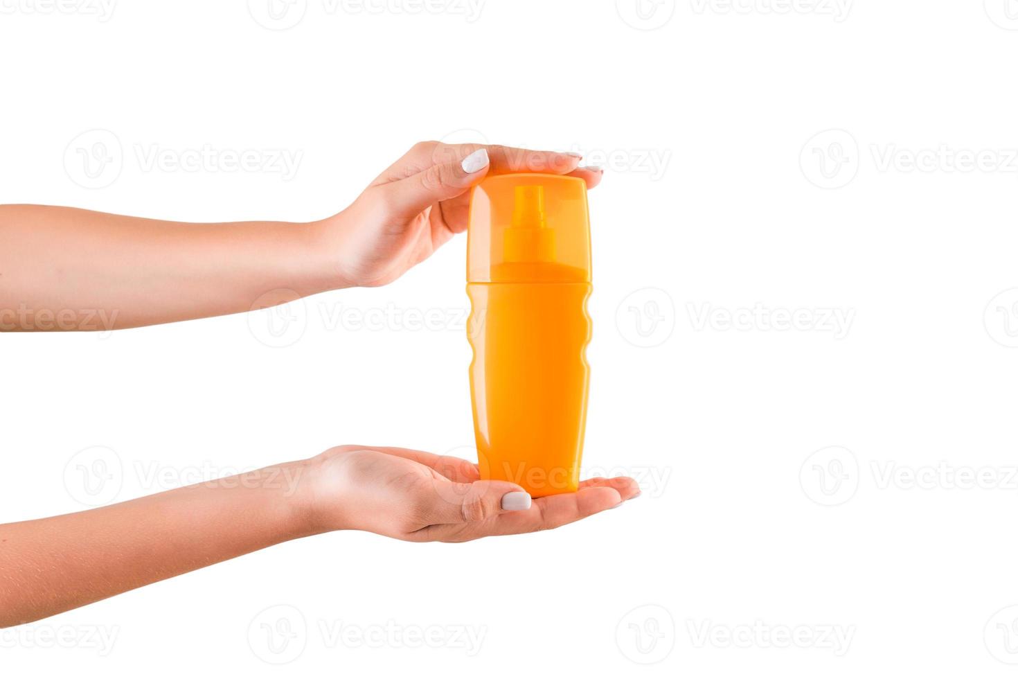 Female hand holding cream bottle of lotion isolated. Girl give cosmetic products on white background photo