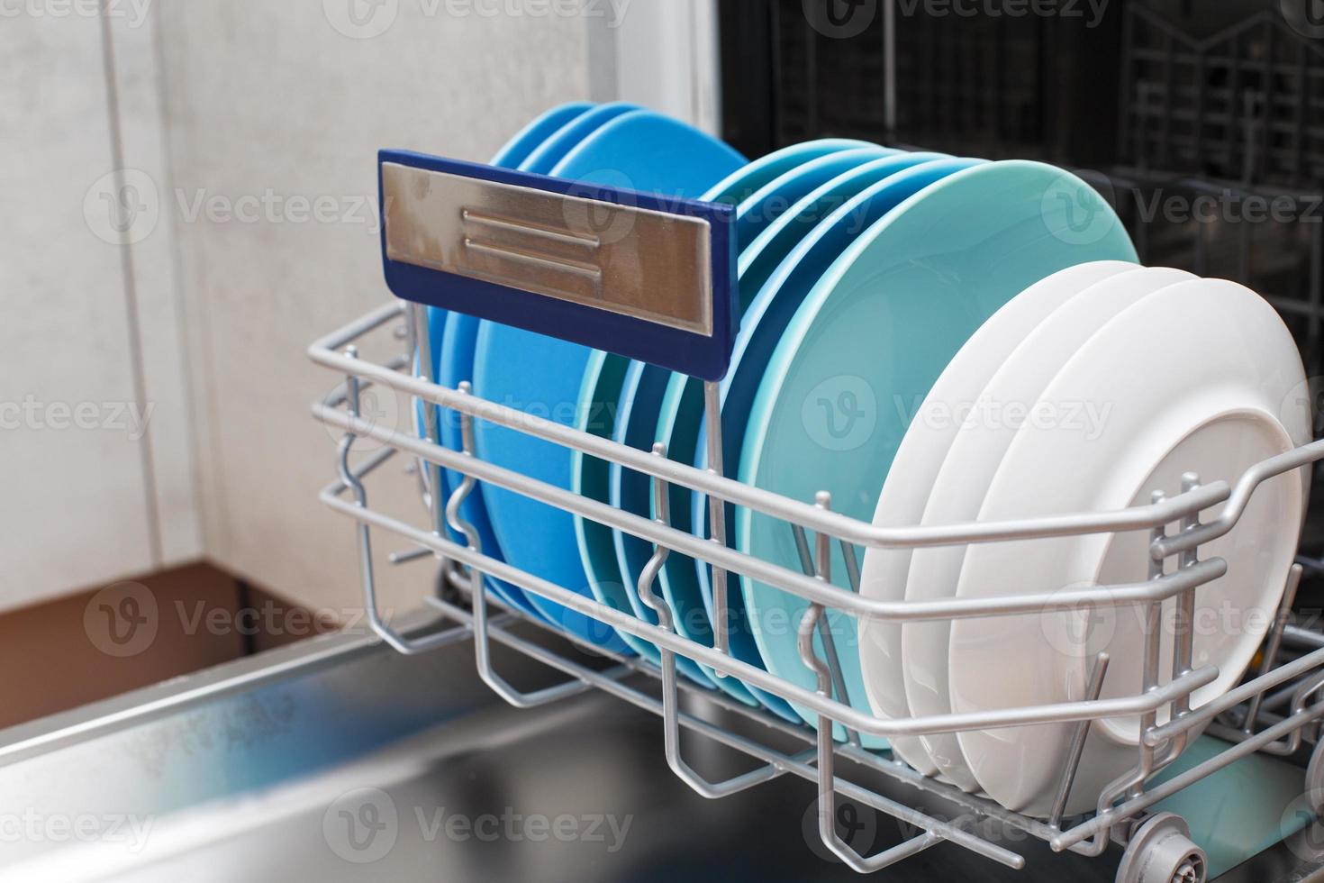 Open dishwasher with clean dishes in the kitchen photo