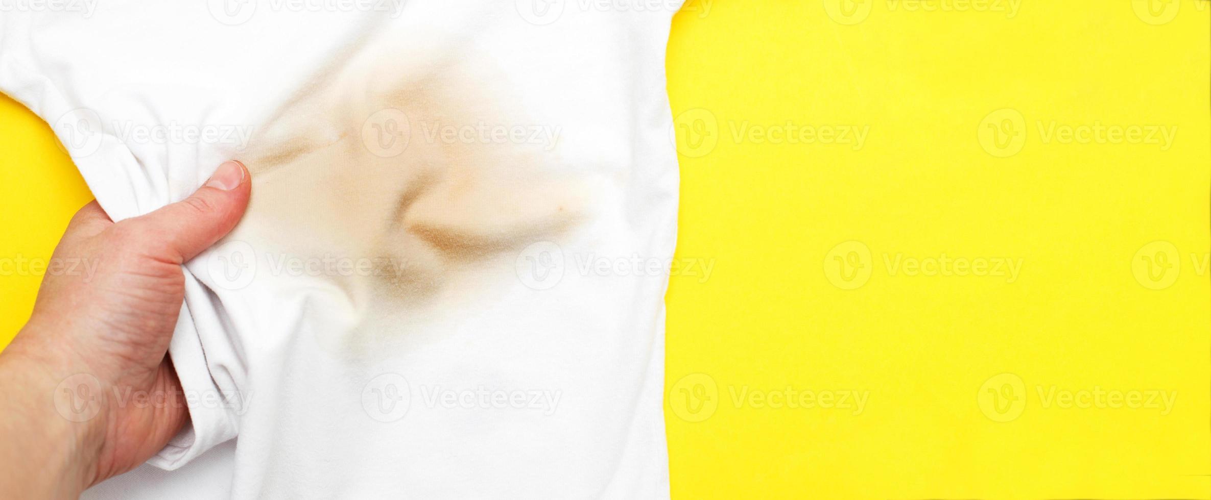 female hand holding white clothes with a dirty stain photo