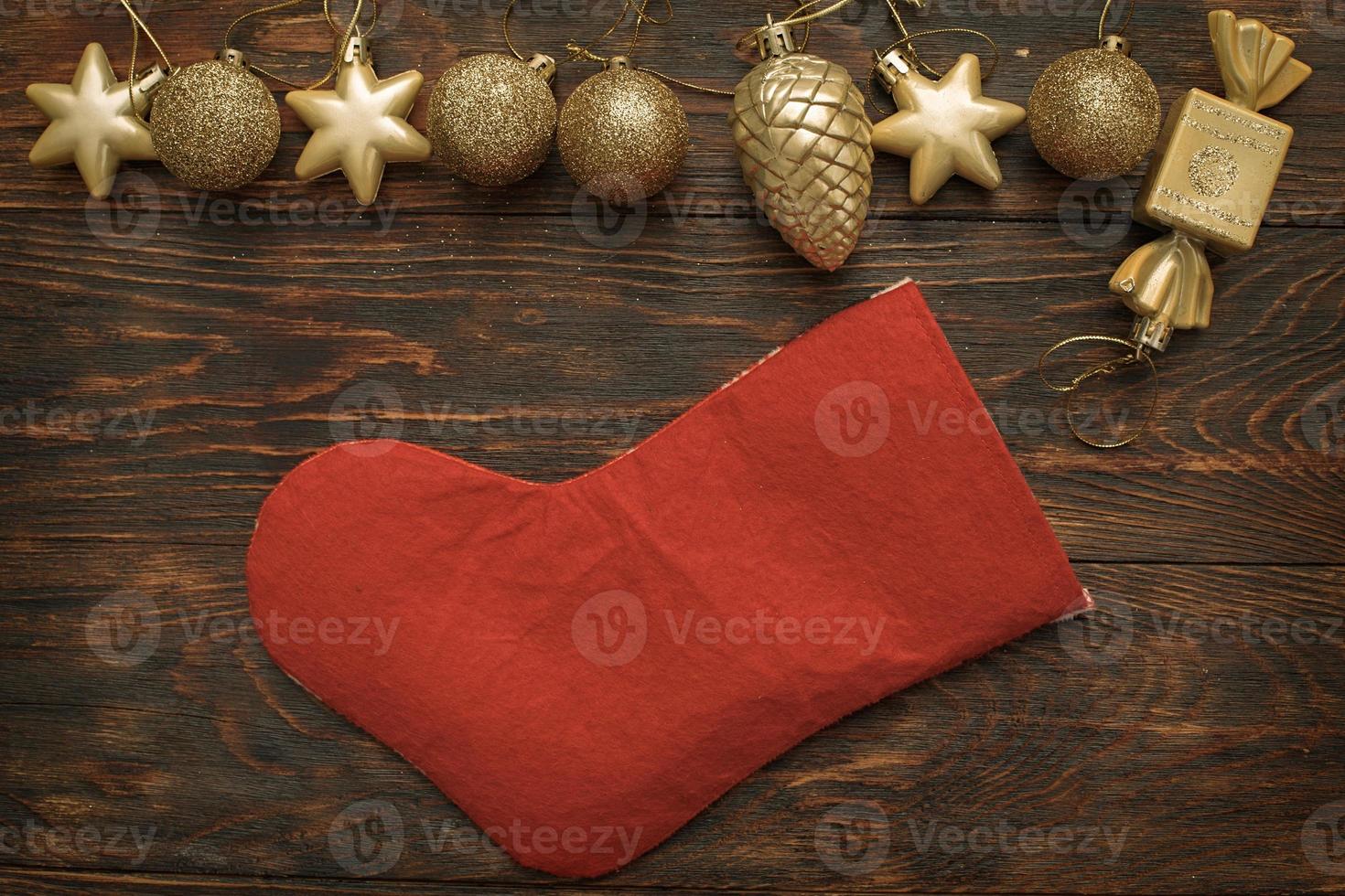 Gold balls and toys with Christmas sock on a wooden background photo