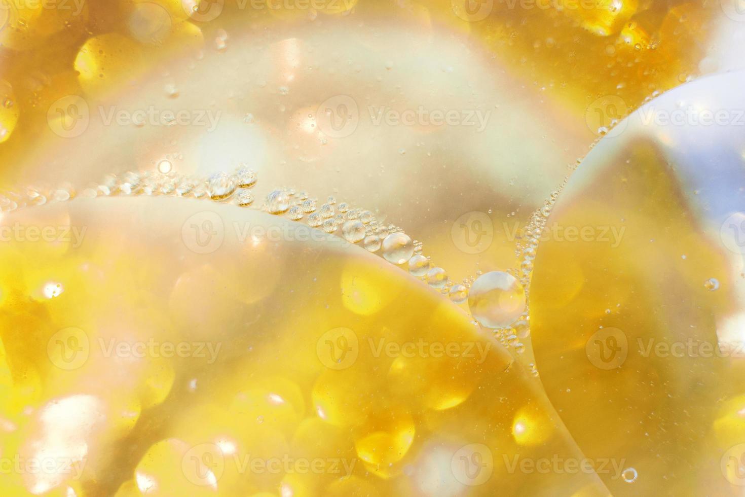 Gold Oil bubbles close up. circles of water macro. abstract shiny yellow background photo