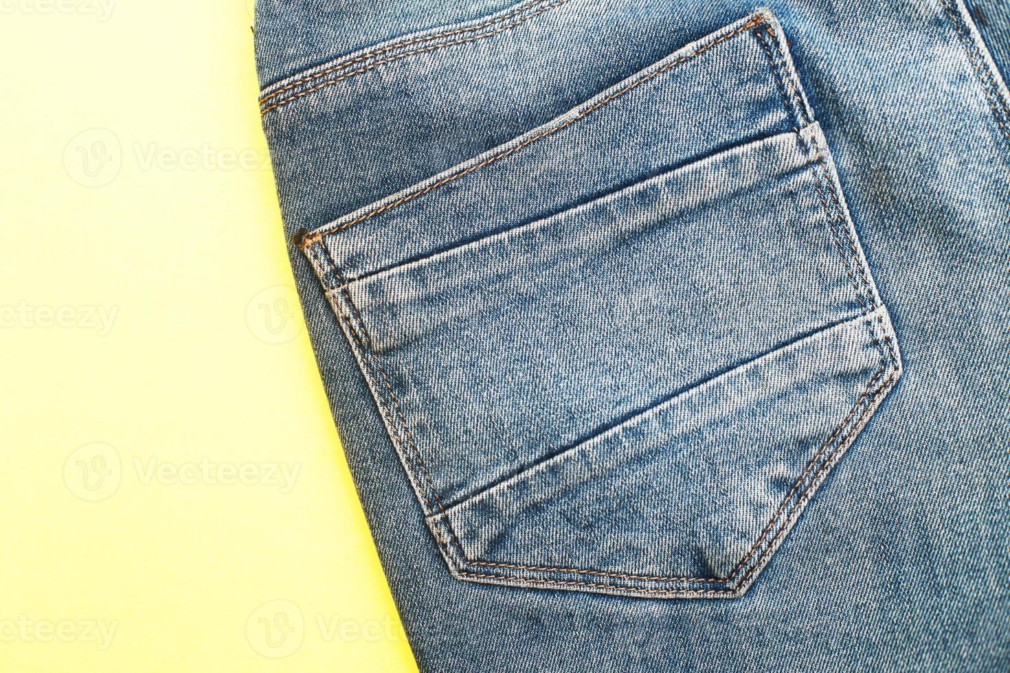 Back pockets of blue jeans on yellow background photo