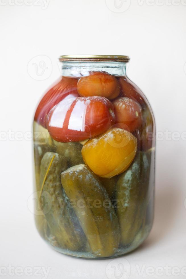 spoiled can of vegetable seaming. Glass jar with homemade pickled tomatos and cucumbers with white fungus photo