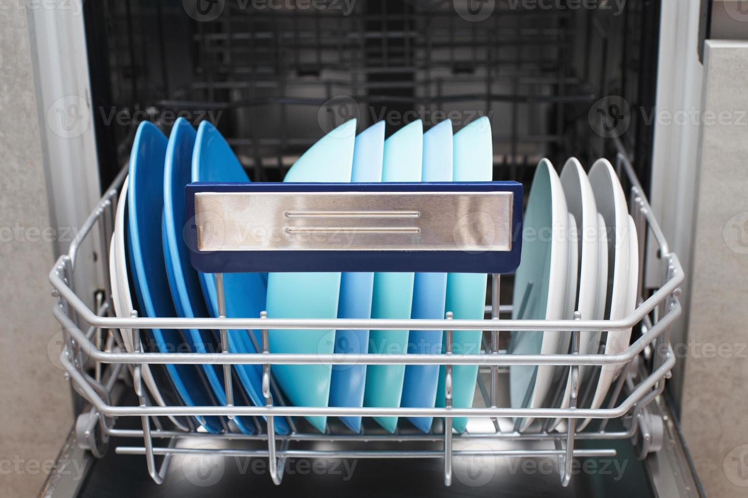 Open dishwasher with clean dishes in the kitchen photo