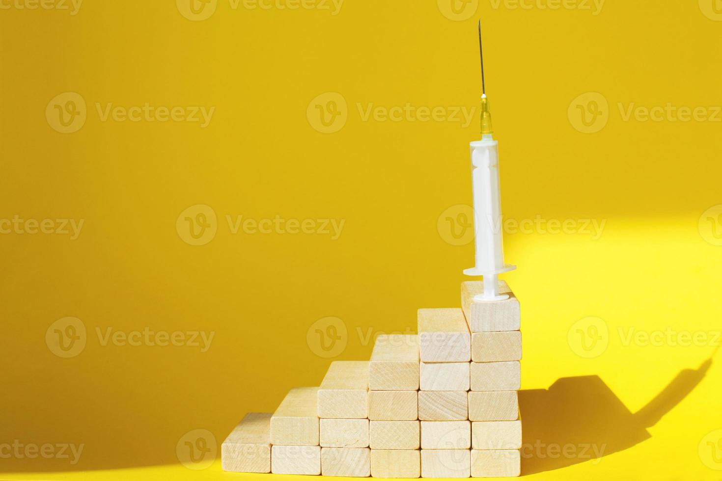 medical syringe on ladder made of wooden sticks. drugs, vaccination concept. hard light photo