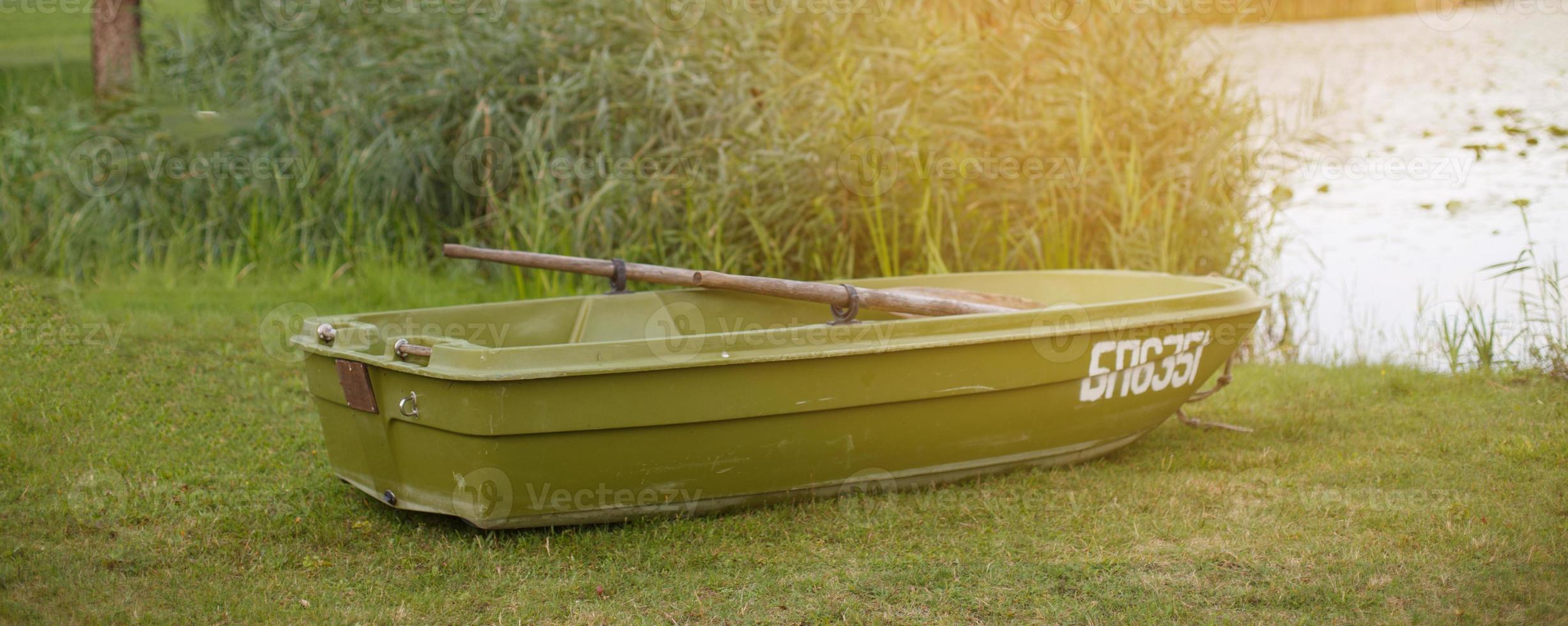 a boat on the grass of the shore of calm lake photo