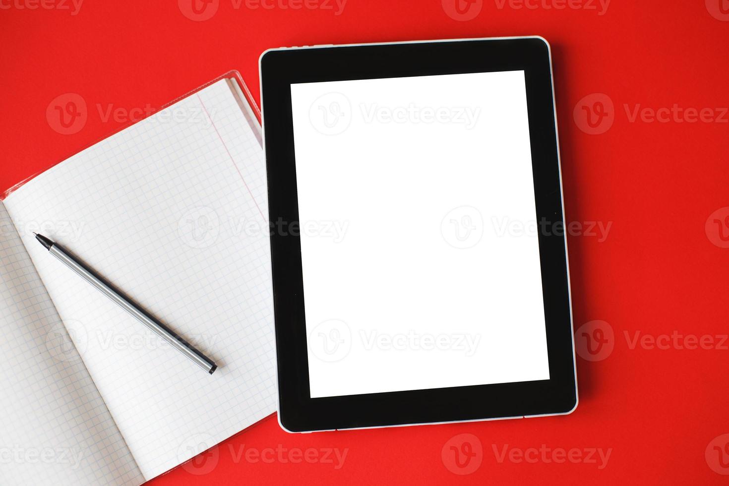 Top view open notepad and a gadget with mock up on red background. photo