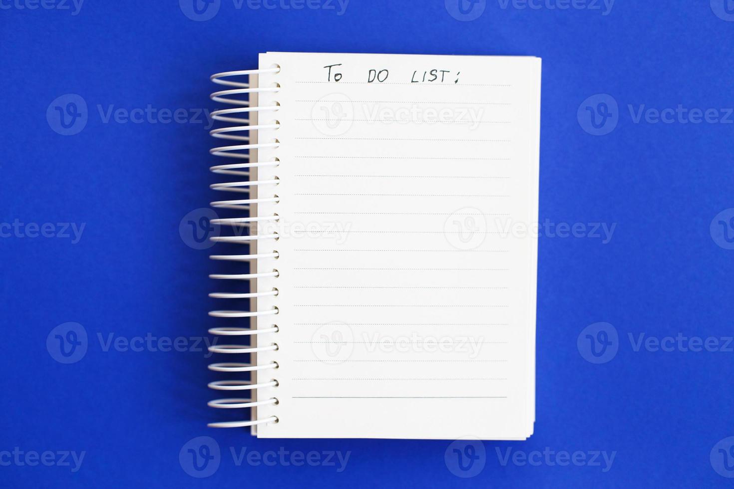 Top view of blank note paper on blue background. to do list photo