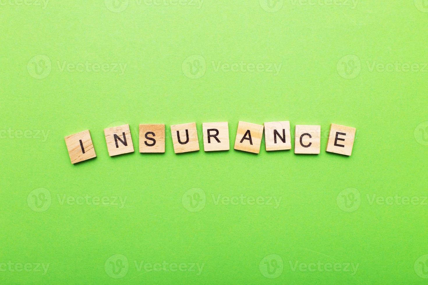 inscription insurance on a green background made by wooden blocks photo