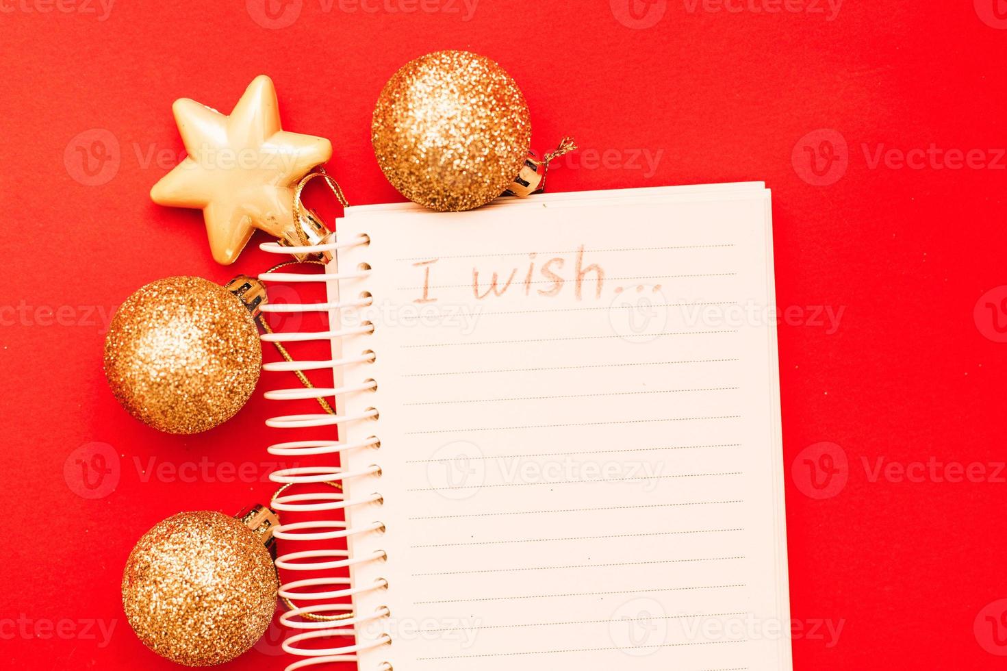 Gold Christmas balls and toys with empty blank note sheet on a red background photo