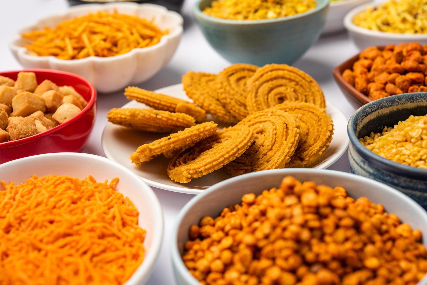 Indian Tea time snacks in group. Sev, chivda, farsan, mixture, bakarwadi served in different bowls photo