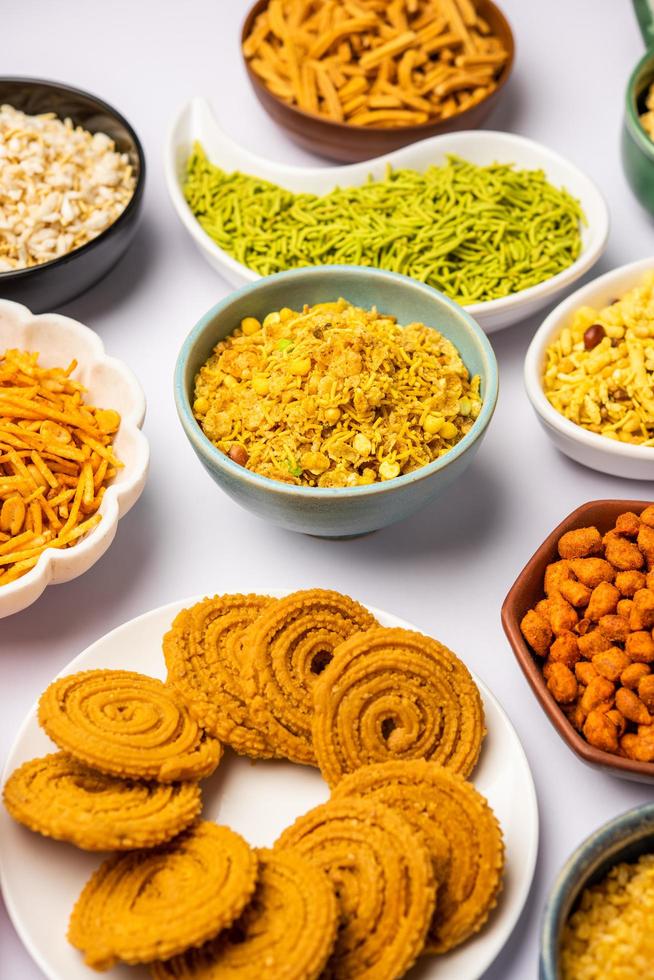 Indian Tea time snacks in group. Sev, chivda, farsan, mixture, bakarwadi served in different bowls photo