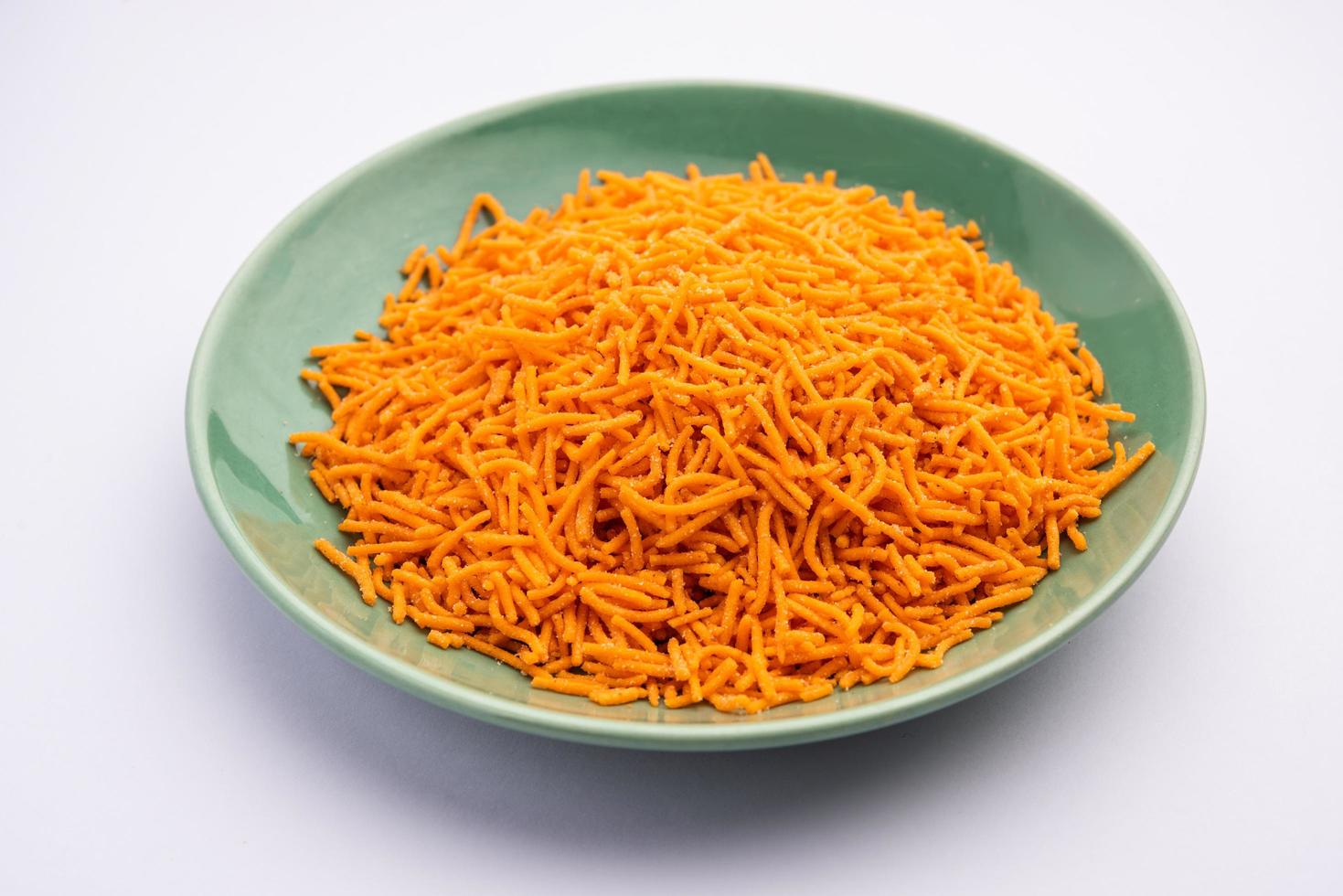 Tomato sev is a crispy crunchy orange colored flavored fried farsan with salt and spice powders photo