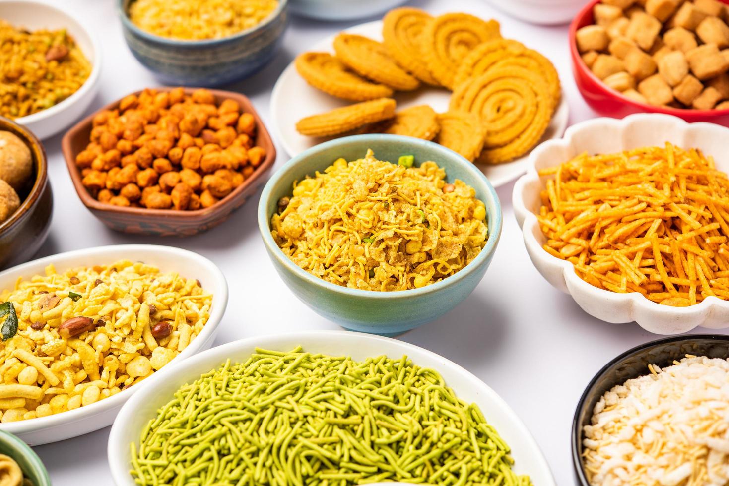 Indian Tea time snacks in group. Sev, chivda, farsan, mixture, bakarwadi served in different bowls photo