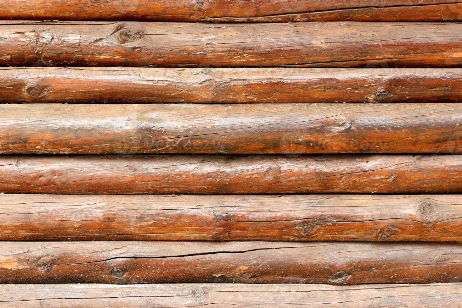 wall made of wooden logs background. wooden beams fence texture photo